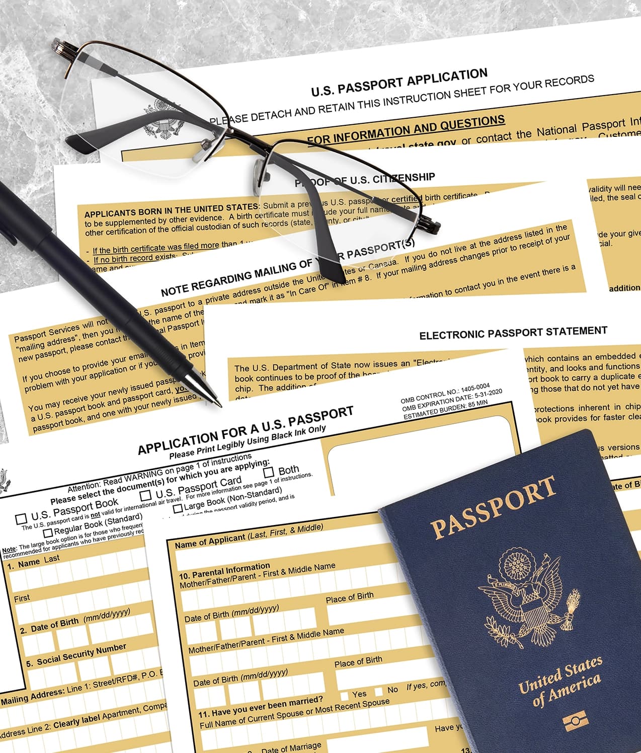 United States passport application forms laid out with reading glasses and a pen